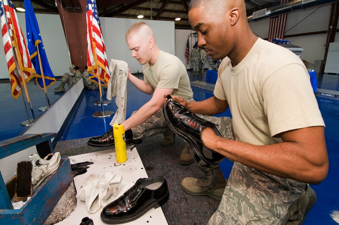 ANDREWS AIR FORCE BASE, Md. – Airman 1st Class Wade Davis, left, 11th Force Support Squadron ceremonial guardsman, and fellow ceremonial guardsmen, Senior Airman Brandon Fisher, polish their shoes for an upcoming retirement cerement Jan. 19.  (U.S. Air Force photo/Bobby Jones)