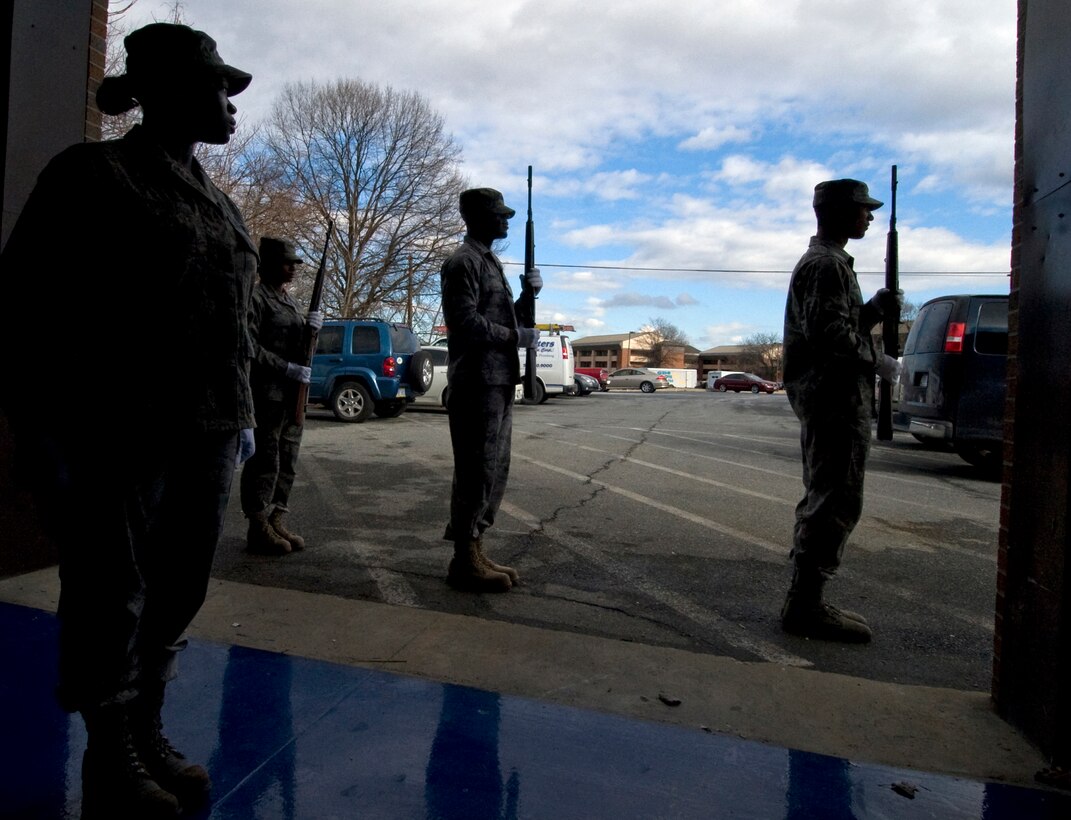 ANDREWS AIR FORCE BASE, Md. – A silhouetted Staff Sgt. Eboni Stewart, left, 11th Force Support Squadron NCO in charge of firing party, commands the firing party to present arms position during a training session at the honor guard facility Jan. 19.  (U.S. Air Force photo/Bobby Jones)