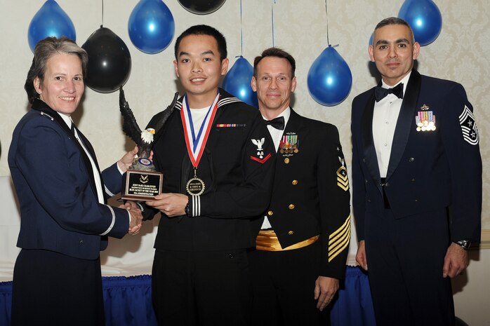 Col. Martha Meeker, left, Master Chief Billy Cady, center, and Chief Master Sgt. Jose LugoSantiago, right, presents Machinist's Mate 3rd Class Petty Officer Michael Phaibon with the Blue Jacket of the Year award for 2010 during the annual awards banquet held at the Charleston Club Jan 20, 2010. Airmen, Sailors and civilians were presented with an award for their outstanding accomplishments from one of the 15 different categories recognized. Unable to attend the banquet due to deployment or other reasons was, from the 628th Mission Support Group, Noncommissioned Officer of the Year Staff Sgt. Akeem Parks; from the 628 MSG, Senior Noncommissioned Officer of the Year Master Sgt. Michael Patterson; from the 628 MSG, First Sergeant of the Year Master Sgt. Steven Hart; and from the Naval Weapons Station, Sailor of the Year Personnel Specialist 1st Class Petty Officer James Long. Colonel Meeker is the Joint Base Charleston commander, Master Chief Cady is the Naval Support Activity command master chief and Chief LugoSantiago is the 628th Air Base Wing command chief. (U.S. Air Force photo/Tech. Sgt. Chrissy Best)