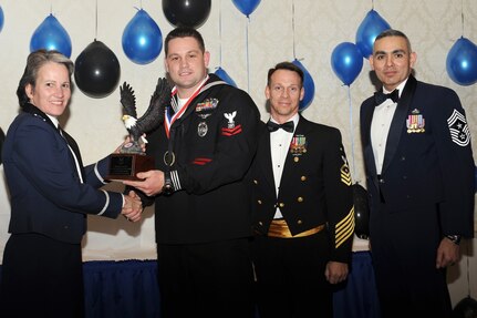 Col. Martha Meeker, left, Master Chief Billy Cady, center, and Chief Master Sgt. Jose LugoSantiago, right, presents Master-at-arms 2nd Class Petty Officer Nicholas Green with the Jr. Sailor of the Year award for 2010 during the annual awards banquet held at the Charleston Club Jan 20, 2010. Airmen, Sailors and civilians were presented with an award for their outstanding accomplishments from one of the 15 different categories recognized. Unable to attend the banquet due to deployment or other reasons was, from the 628th Mission Support Group, Noncommissioned Officer of the Year Staff Sgt. Akeem Parks; from the 628 MSG, Senior Noncommissioned Officer of the Year Master Sgt. Michael Patterson; from the 628 MSG, First Sergeant of the Year Master Sgt. Steven Hart; and from the Naval Weapons Station, Sailor of the Year Personnel Specialist 1st Class Petty Officer James Long. Colonel Meeker is the Joint Base Charleston commander, Master Chief Cady is the Naval Support Activity command master chief and Chief LugoSantiago is the 628th Air Base Wing command chief. (U.S. Air Force photo/Tech. Sgt. Chrissy Best)