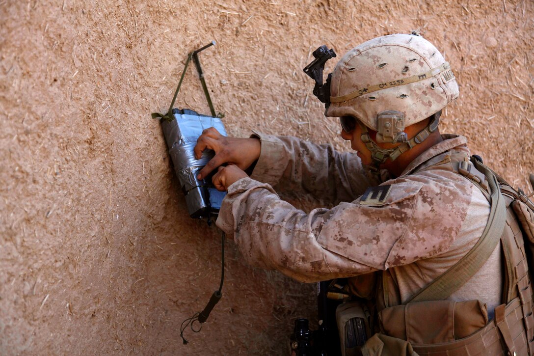 U.S. Marine Corps Lance Cpl. Alex Martinez prepares a wall charge during a census patrol in the Sangin district of Helmand province, Afghanistan, Jan. 18, 2011. Martinez is assigned to Lima Company, 3rd Battalion, 5th Marine Regiment, Regimental Combat Team 2.