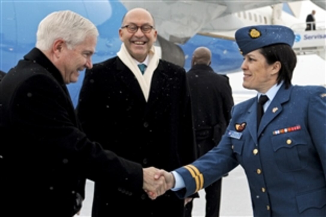 U.S. Defense Secretary Robert M. Gates shakes hands with Canadian Capt. Nancy Silver while U.S. Ambassador to Canada David Jacobson looks on during his arrival in Ottawa, Canada, Jan. 26, 2011.