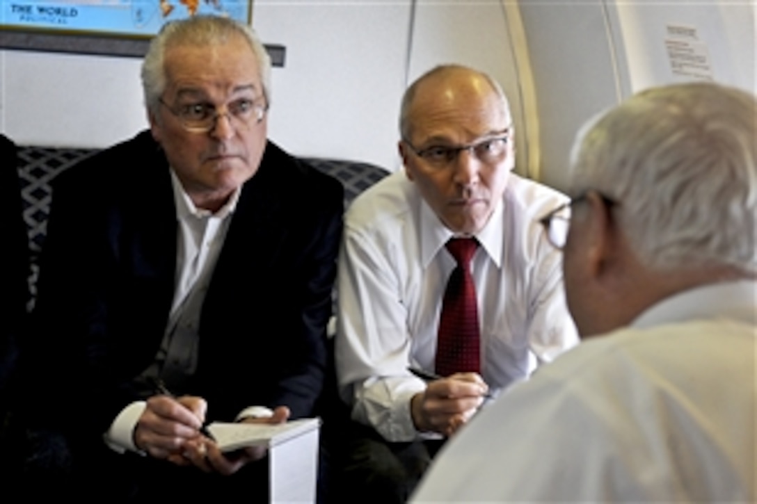 Reporters Robert Burns, left, with the Associated Press and Thom Shanker with The New York Times listen as U.S. Defense Secretary Robert M. Gates briefs the press aboard the C-40 aircraft on their way to Ottawa, Canada, Jan. 26, 2011. Gates is in Canada to attend bilateral meetings with his counterparts from Canada.