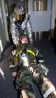 An Airman from the 35th Civil Engineer Squadron drags a person to safety in response to a simulated missile attack at building 1173, Misawa Air Base, Japan, Jan. 25. The response was part of an operational readiness exercise, which tests Airmen's ability to survive and operate during contingency operations. (U.S. Air Force photo/Tech. Sgt. Russell McBride)