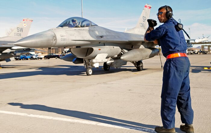 NELLIS AIR FORCE BASE, Nev. -- Airman 1st Class Danitha Amarawardana, 52nd Aircraft Maintenance Squadron crew chief, gives hand signals to an F-16 Fighting Falcon from the 480th  Fighter Squadron just before takeoff Jan. 20. Airman Amarawardana is deployed from Spangdahlem Air Base, Germany, in support of Red Flag 11-2, a combined exercise that provides a realistic combat training environment to the U.S. and its allies. (U.S. Air Force photo/Staff Sgt. Benjamin Wilson)