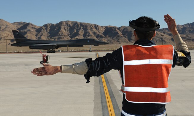 NELLIS AIR FORCE BASE, Nev. -- Senior Airman Kevin Faulds, 28th Aircraft Maintenance Squadron crew chief, marshals a B-1 Lancer from the 34th Bomb Squadron after a mission Jan. 26. Airman Faulds is deployed from Ellsworth Air Force Base, S.D., in support of Red Flag 11-2, a combined exercise that provides a realistic combat training environment to the U.S. and its allies. (U.S. Air Force photo/Staff Sgt. Benjamin Wilson)