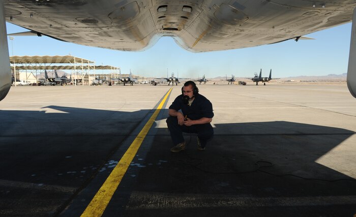 NELLIS AIR FORCE BASE, Nev. -- Senior Airman Sean Flynn, 46th Air Craft Maintenance Squadron crew chief, observes the bottom of an F-15 Strike Eagle from the 85th Test and Evaluation Squadron during a preflight inspection Jan. 26. Airman Flynn is deployed from Eglin Air Force Base, Fla., in support of Red Flag 11-2, a combined exercise that provides a realistic combat training environment to the U.S. and its allies. (U.S. Air Force photo/Staff Sgt. Benjamin Wilson)