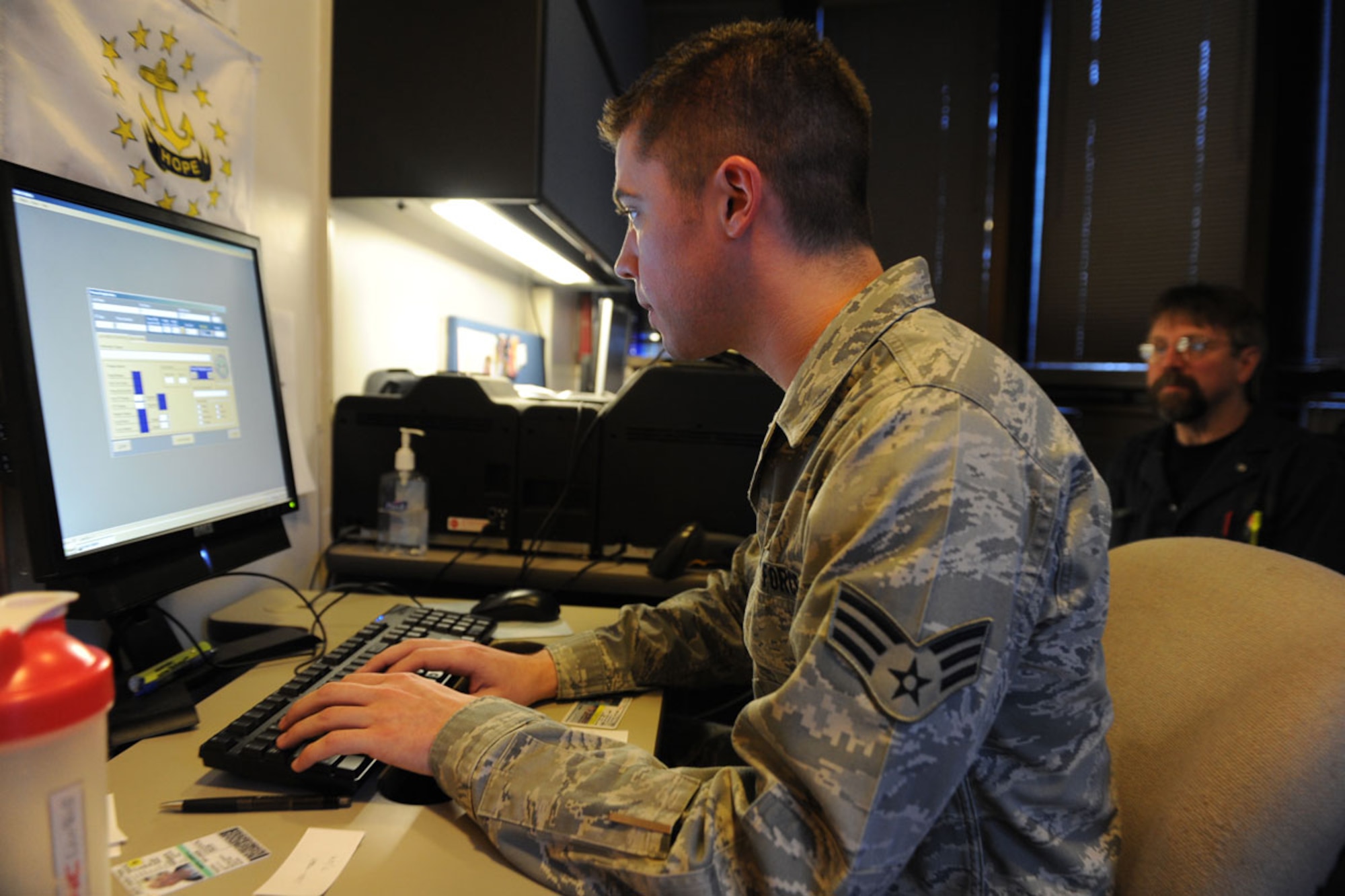 Senior Airman Richard Wright, 673d Security Forces Squadron, Visitor Control Center technician, inputs data for Bruce Jordan, a contractor who requires freqent base access, into the new DBIDS system. (U.S. Air Force photo/Luke Waack)
