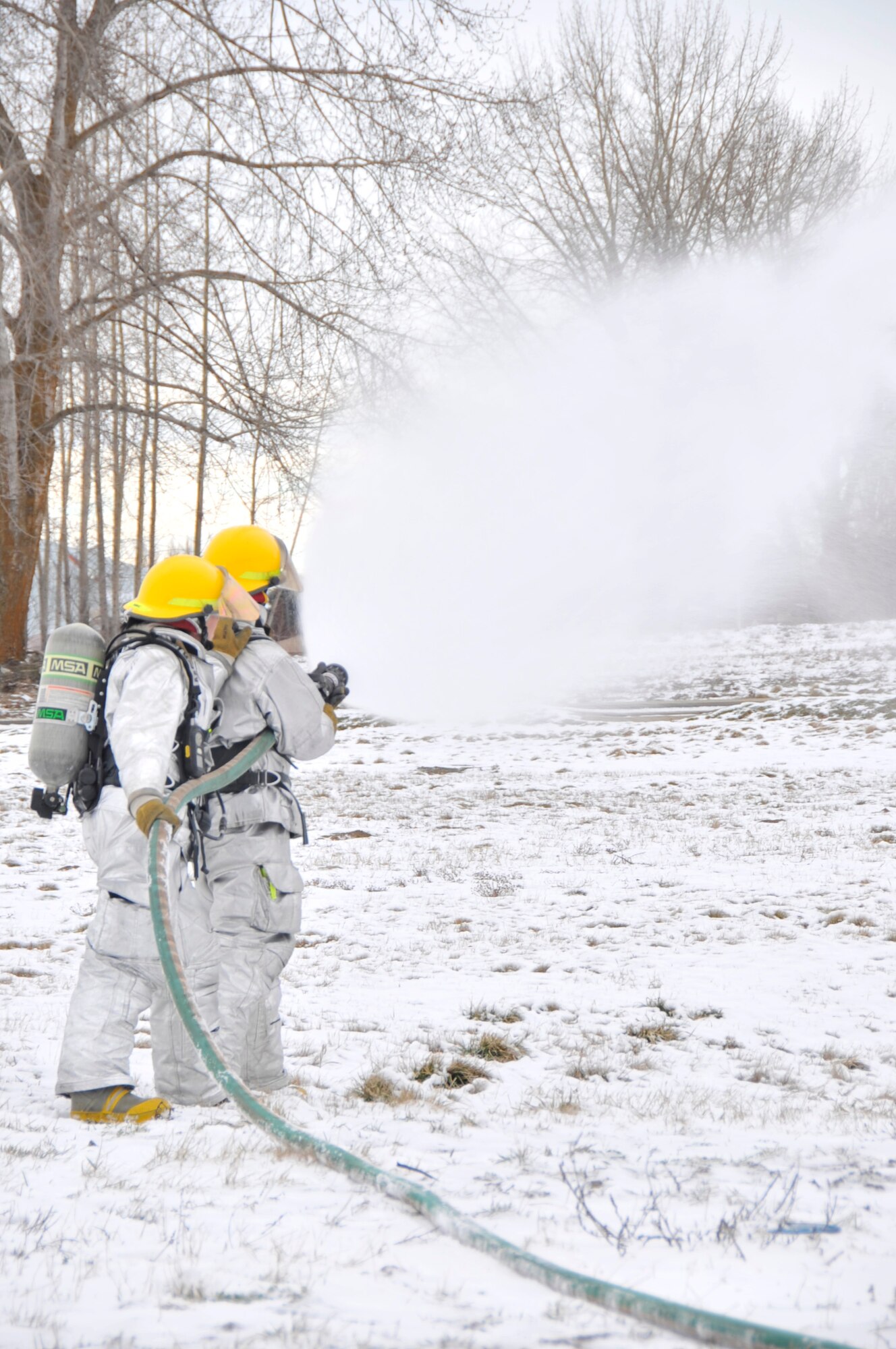 Airman 1st Class Josh Lupidi, 92nd Civil Engineering firefighter and Airman 1st Class Sam Tuscany, 92nd Civil Engineering firefighter, practice supression techniques here Jan. 20, 2011. (U.S. Air Force photo/ Airman 1st Class Mary Norenberg)
