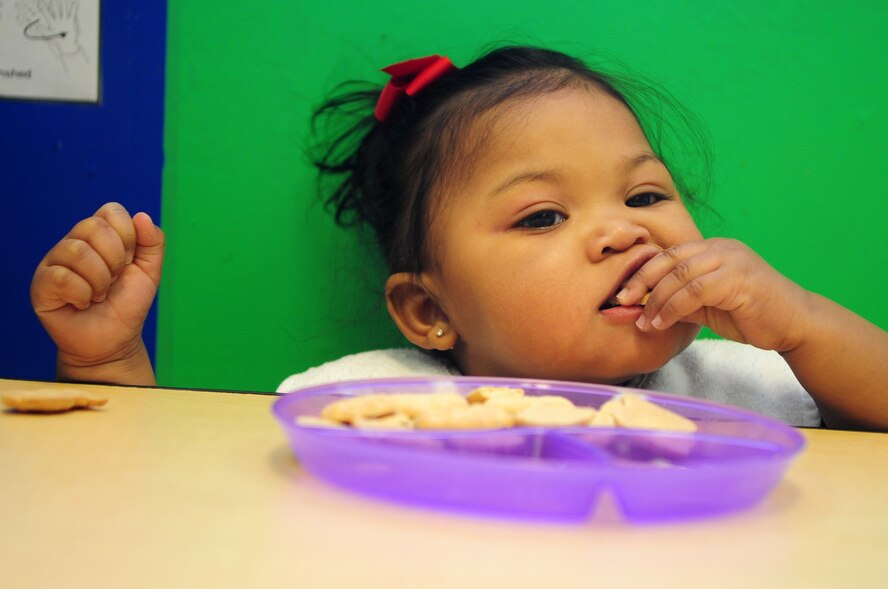 Emiah Dees, 11 months, snacks on animal crackers at the Barksdale Child Development Center located on Barksdale Air Force Base, La., Jan. 27. Emiah is the daughter of Tech. Sgt. Yvonne Dees, 2nd Force Support Squadron, and Staff Sgt. Eric Dees, 2nd Communications Squadron. The CDC, which is Department of Defense certified and accredited by the National Association for the Education of Young Children, provides childcare for military and DoD civilian children during the duty week. (U.S. Air Force photo/Senior Airman Joanna M. Kresge)