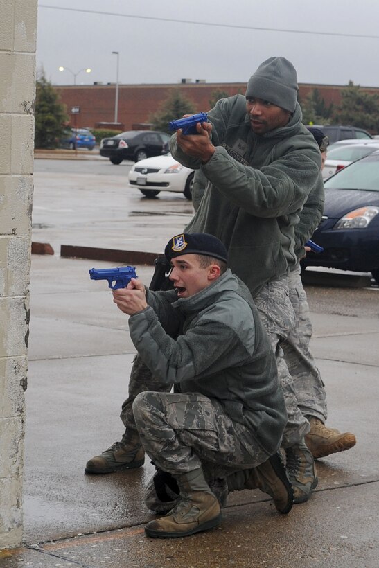 LANGLEY AIR FORCE BASE, Va. -- Senior Airman Patrick McCoy and Senior Airman Eugene Harrigan, 633d Security Forces Squadron response force personnel, practice maneuvering tactics during active shooter training at the SFS building Jan. 26. Security Forces consolidated a year-long on-the-job training into a month-long battery of required tasks to minimize the impact on day-to-day operations. (U.S. Air Force photo/Staff Sgt. Ashley Hawkins)(RELEASED)