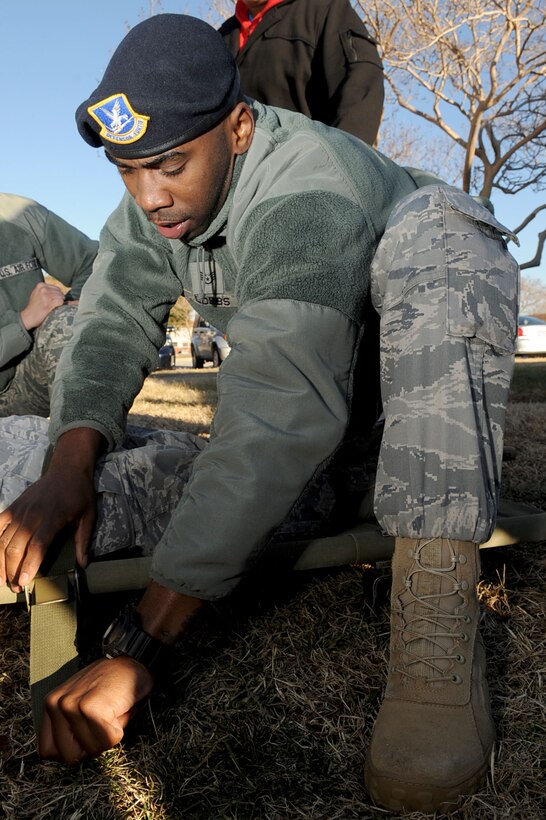 LANGLEY AIR FORCE BASE, Va. --Staff Sgt. Christopher Cobbs, emergency communication controller with the 633d Security Forces Squadron, straps an Airman to a stretcher during the hands-on portion of self aid/buddy care outside the SF building Jan. 21. Security Forces consolidated on-the-job training into a month-long battery of required tasks to minimize the impact on day-to-day operations. (U.S. Air Force photo/Staff Sgt. Ashley Hawkins)(RELEASED)