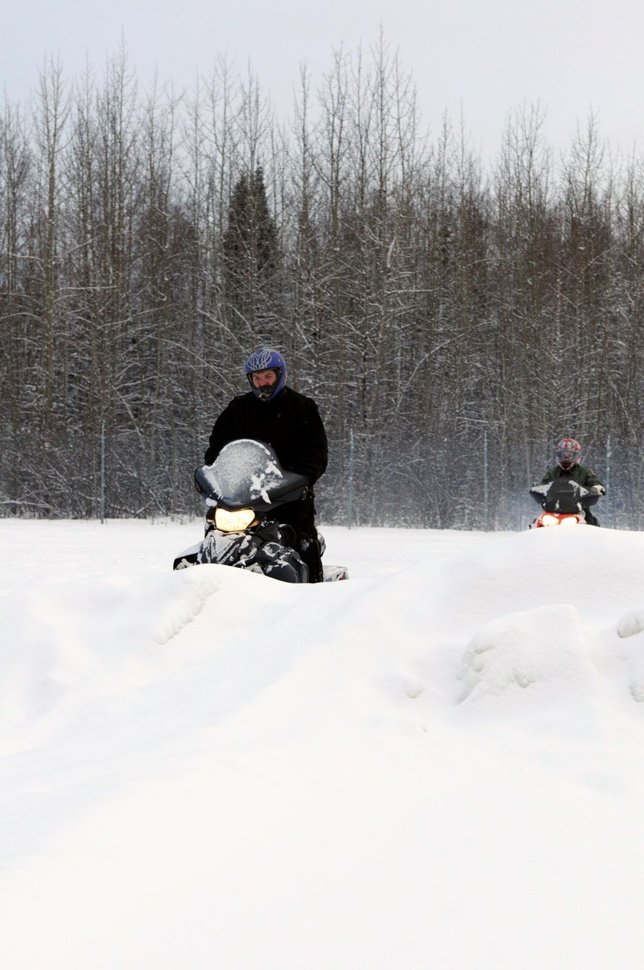 Nathan Dermer goes over controls of snow machines before students move outside for actual operation of their snowmobiles. (U.S. Air Force photo/Steve White)