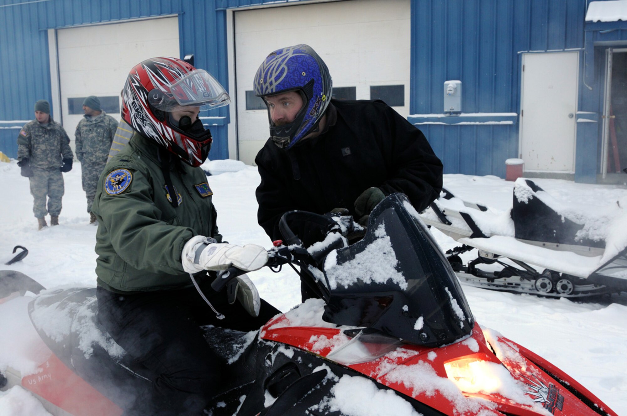 Nathan Dermer, Joint Base Elmendorf-Richardson Outdoor Recreation???Richardson facilites manager, goes over controls of snowmachines with Air Force 1st Lt. Elizabeth Combs, 673d Aerospace Medicine Squadron, before actual operation of the machines. The 1.5 hour course can be reserved for a $40 fee, which can be deducted from a student???s first snowmachine rental. The course is offered Tuesdays at 5:30 p.m., Wednesdays at 5 p.m., and Thursdays at 11:30 a.m. Students are required to bring their own cold weather clothes. For more information, call 384-1475. (U.S. Air Force photo/Steve White)
