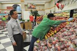 New commissary manager Juan Rodriguez chats with associate Tony Reyes as he stocks fresh New York apples in the commissary produce department at Randolph Air Force Base, Texas, Jan. 21. (U.S. Air Force photo/David Terry)