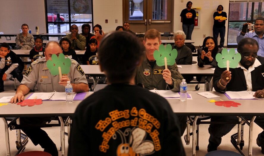 VALDOSTA, Ga.--  The judges for the King and Queen Spelling Bee at William Gaines Nunn Elementary School raise a green sign across the board for Ma’at Chastang, fifth-grade student from W.G. Nunn Elementary School, and the winner of the King and Queen Spelling Bee Jan. 21. Ma’at beat out 16 other students to gain first place. (U.S. Air Force photo/Airman 1st Class Joshua Green)(RELEASED)
