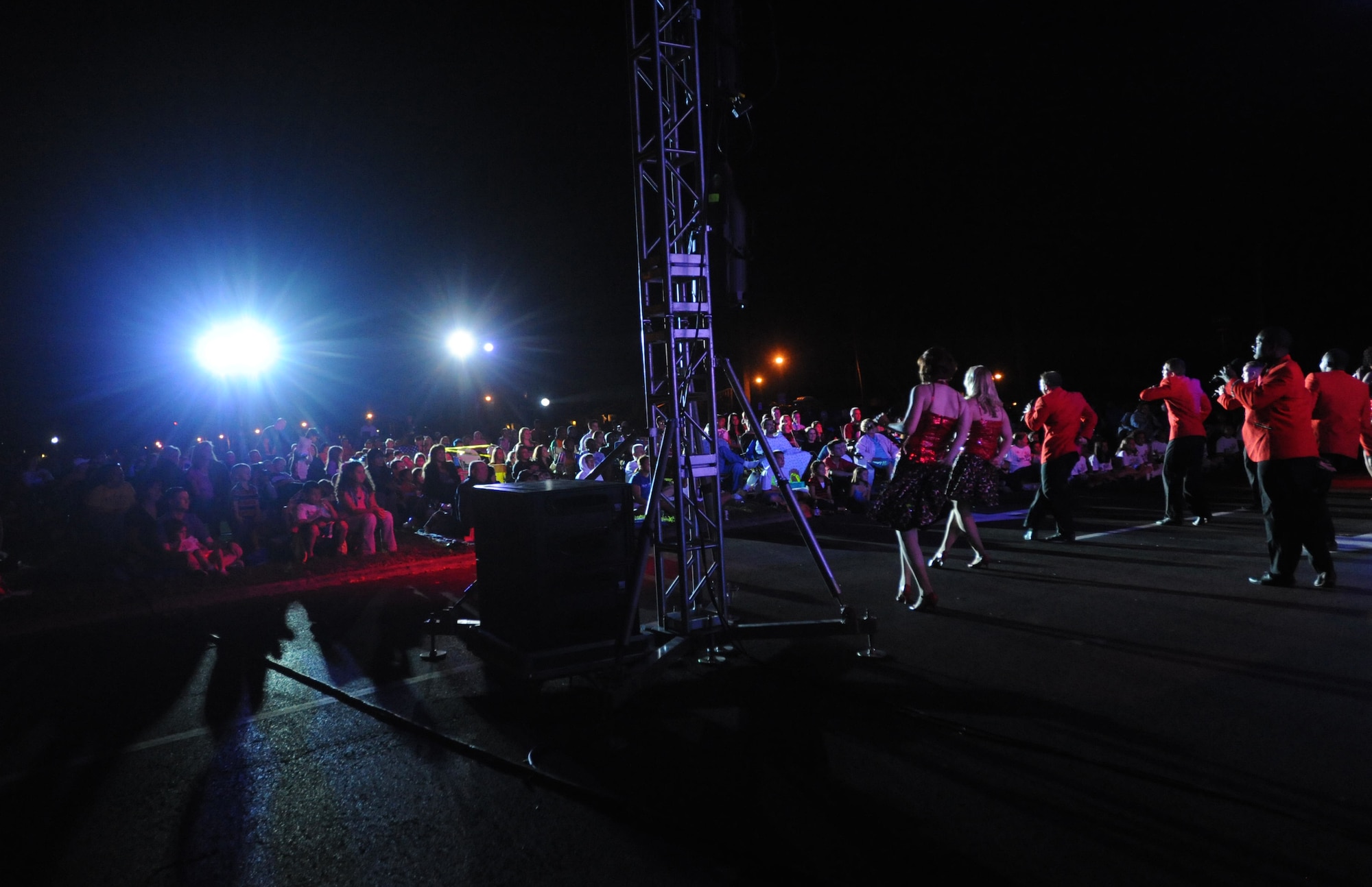 Tops in Blue entertainers line the edge of the crowd during a performance at Freedom Tower on Joint Base Pearl Harbor-Hickam, Hawaii, Jan. 26. The members of Tops in Blue must complete a highly-accelerated educational process to prepare them to succeed as world-class entertainers during their 9-month tour. Some of the performers' responsibilities include setting up the stage, lighting, audio and special effects equipment. They must learn to work as a self-contained operational unit that can manage their own lodging, transportation, dining and wardrobe. (U.S. Air Force Photo/Airman 1st Class Lauren Main)