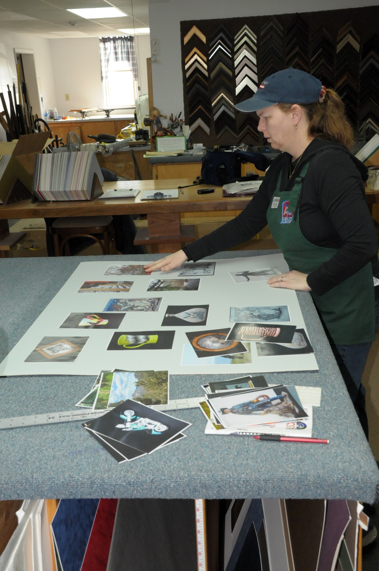 Kimberly Fetterer assembles a layout of work produced by Warren members for the Air Force gallery submission at the Art and Crafts Hobby Shop here Jan. 26. (U.S. Air Force photo by Blaze Lipowski)