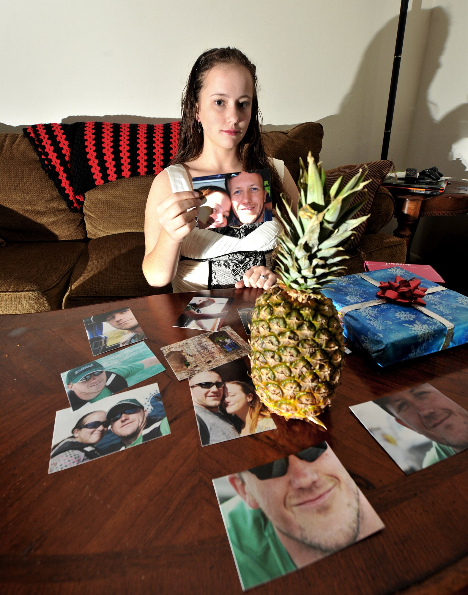 A pineapple sits on a table surrounded by pictures and a Christmas present during a portrait of Airman 1st Class Brigitte Brantley-Sisk Jan. 12, 2011. Her husband told her in his deployed location there wasn't any pineapples, so she bought him one for his homecoming and a present because he missed Christmas. Airman Brantley-Sisk is a 23rd Wing Public Affairs journalist. (U.S. Air Force photo/Airman 1st Class Joshua Green)
