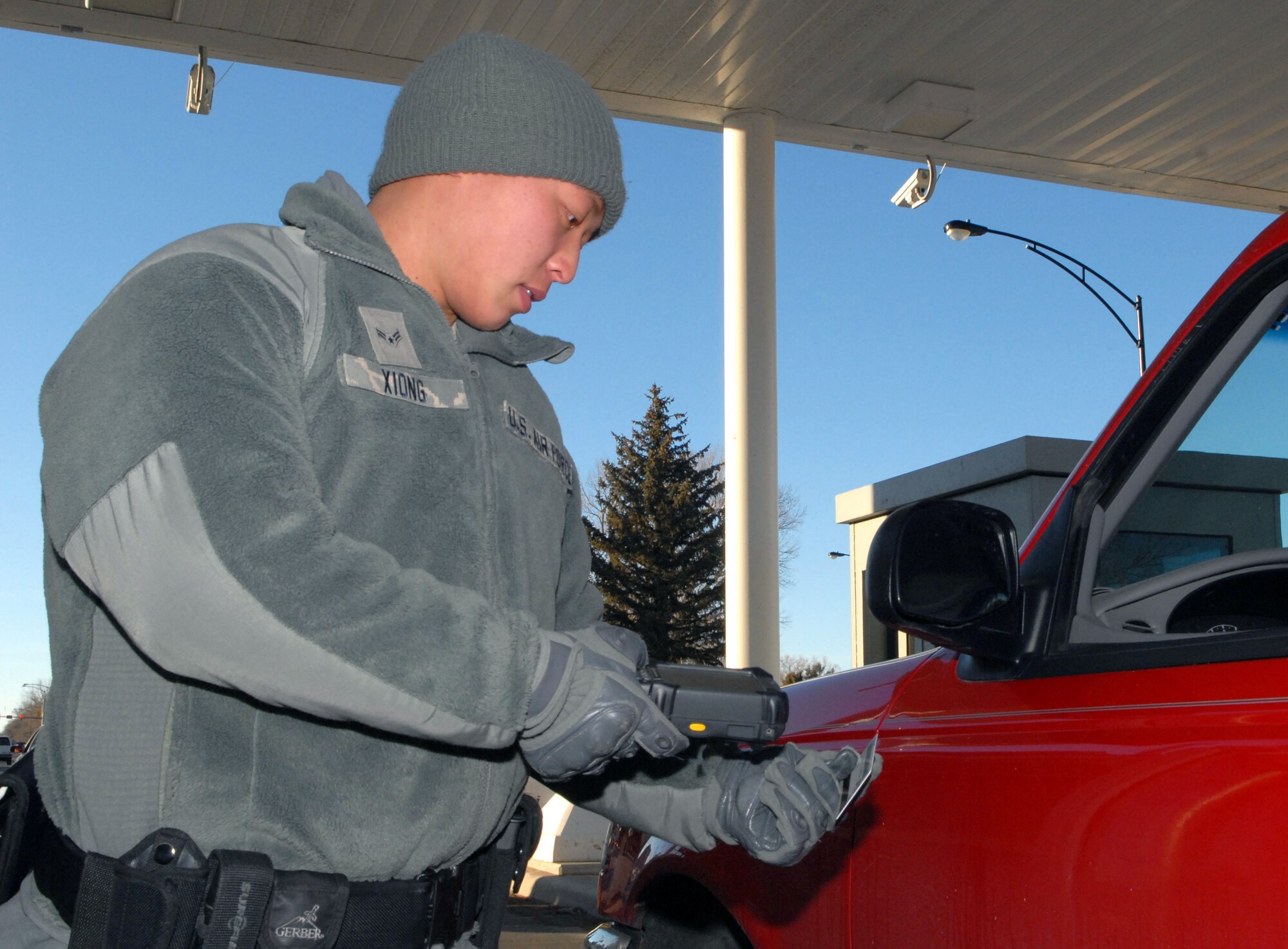Airman 1st Class Mongnchi Xiong, 90th Security Forces Squadron, scans an ID card using the Defense Biometrics Identification System at Warren’s main gate Jan. 24.(U.S. Air Force photo by R.J. Oriez)