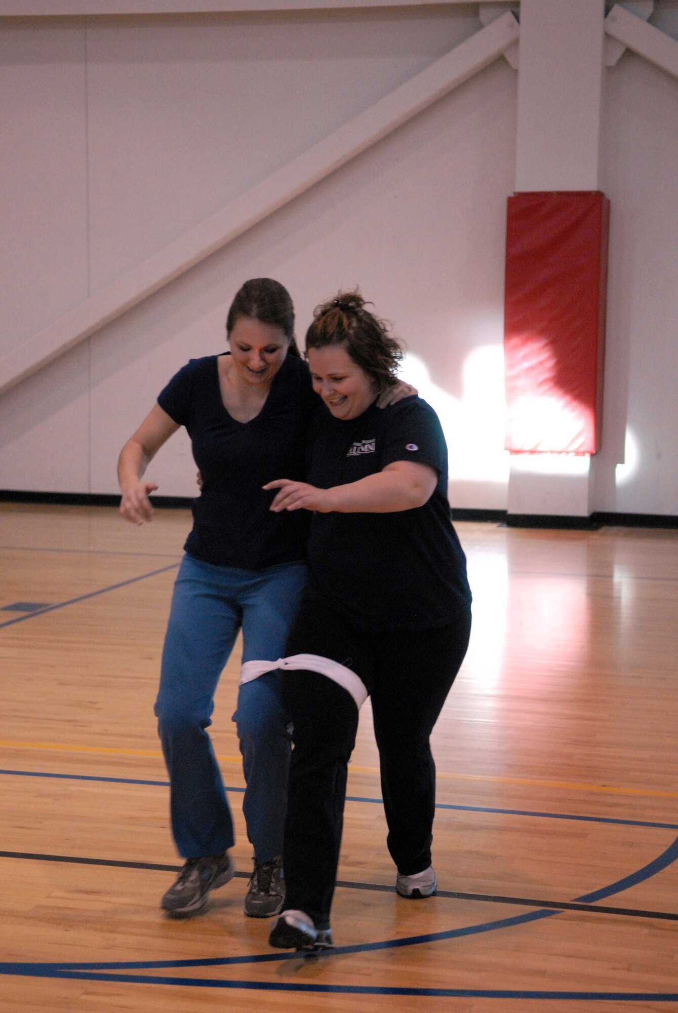 Jamie Protte and Joanne Watt, both from 90th Force Support Squadron, compete in the three-legged race at the Warren Fitness Challenge kick off in Freedom Hall Fitness Center, Jan. 21. Ms. Protte and Ms. Watt are members of the Thinner Winners team. (U.S. Air Force photo by R.J. Oriez)