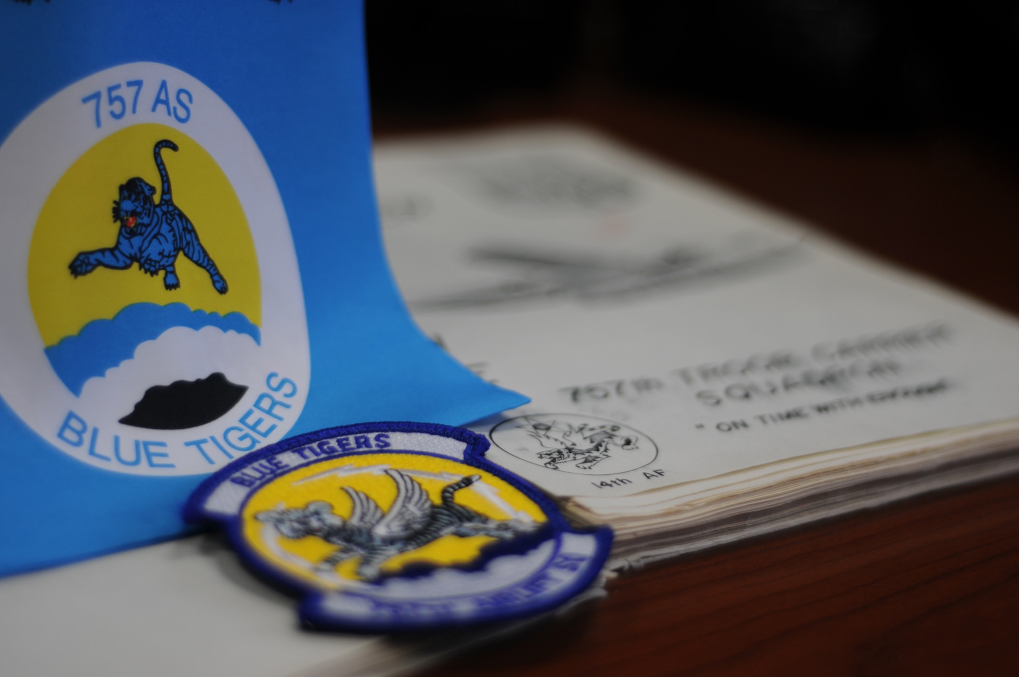 The 1958 cover is identical to 1957's, but with the addition of the striped winged beast known today as the 757th Blue Tiger. The tiger is featured on the Buckstone Carrier cover next to a modern 757th Airlift Squadron patch and ascot. U.S. Air Force photo by Mr. Eric M. White