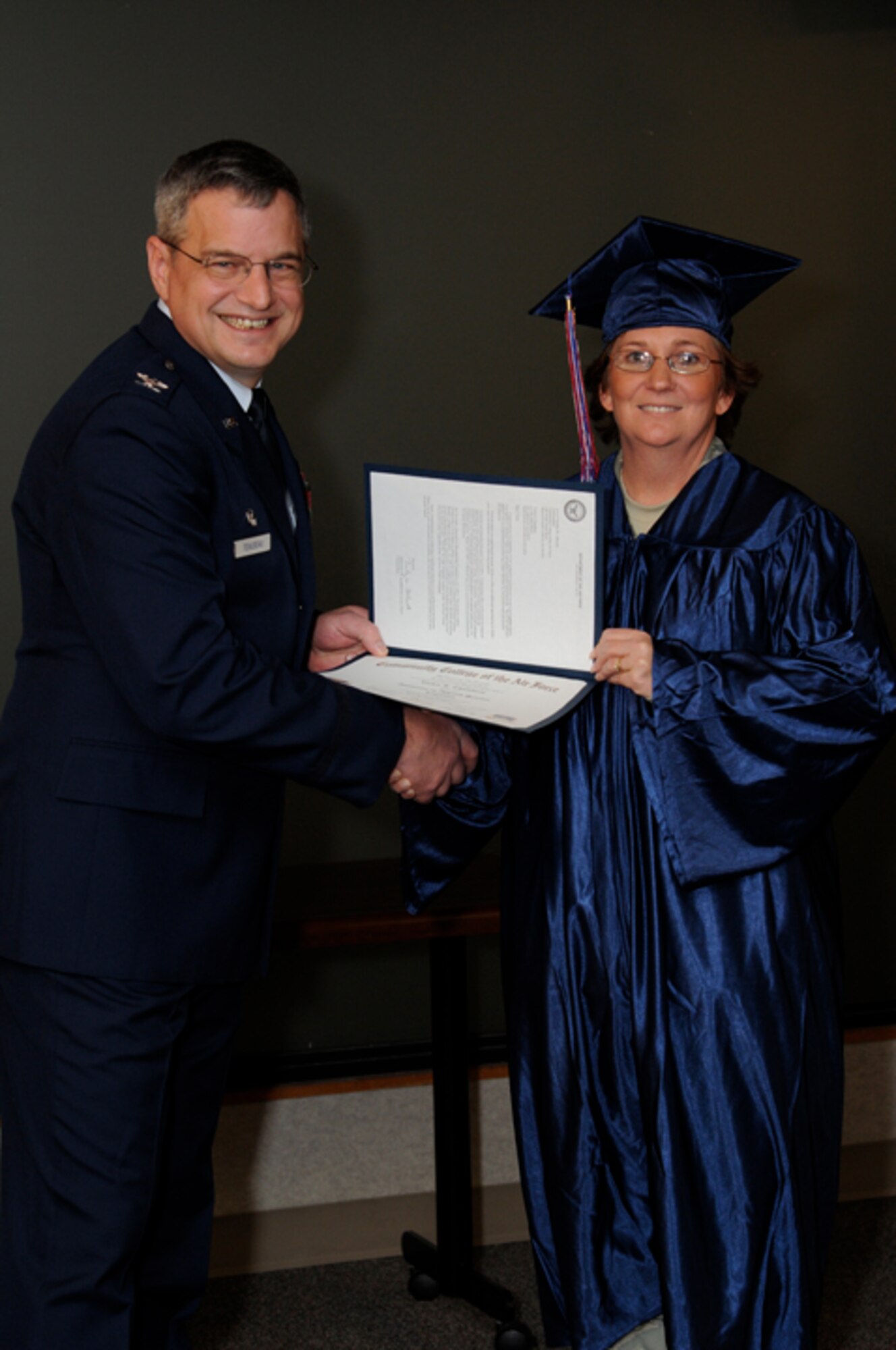 Master Sgt. Vickie Chambers, 442nd Airman and Family Readiness noncommissioned officer in charge, receives her Community College of the Air Force Associate of Science degree in Logistics in a ceremony Jan. 9, 2011. Twenty-six other reservists from the 442nd Fighter Wing also received their CCAF degrees in a ceremony officiated by Col. Alan Teauseau, 442nd Mission Support Group commander. The 442nd Fighter Wing is an A-10 Thunderbolt II Air Force Reserve unit at Whiteman Air Force Base, Mo. (U.S. Air Force photo/Staff Sgt. Jonathan Adams)