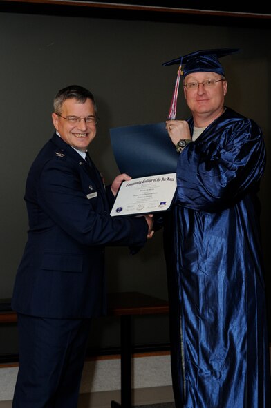 Tech. Sgt. Bryan Byler, 442nd Security Forces, receives his Community College of the Air Force Associate of Science degree in Criminal Justice in a ceremony Jan. 9, 2011. Twenty-six other reservists from the 442nd Fighter Wing also received their CCAF degrees in a ceremony officiated by Col. Alan Teauseau, 442nd Mission Support Group commander. The 442nd Fighter Wing is an A-10 Thunderbolt II Air Force Reserve unit at Whiteman Air Force Base, Mo. (U.S. Air Force photo/Staff Sgt. Jonathan Adams)