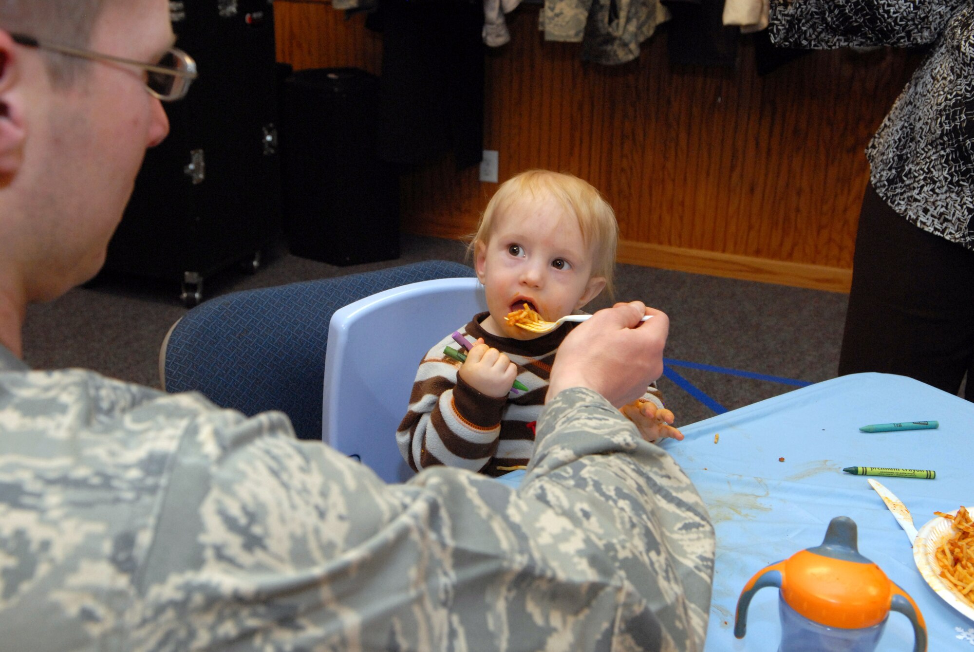 One-year old William Lunsford III, is fed spaghetti by his father, Capt. William Lunsford II, 90th Medical Support Squadron, during the annual deployed families spaghetti dinner, Jan. 21. The dinner was sponsored by the Airmen and Family Readiness Center here and was held at the Chapel Activities Center. Captian Lunsford recently returned from a six-month deployment to Kabul, Afghanistan. (U.S. Air Force photo by R.J. Oriez)