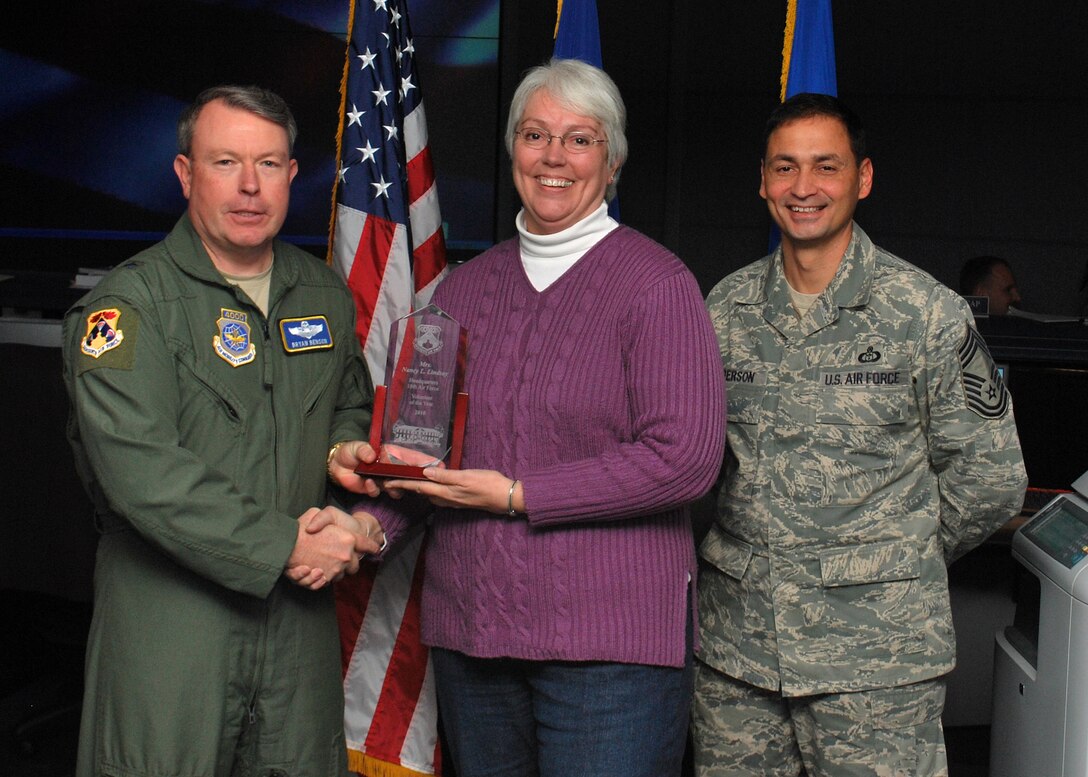 SCOTT AIR FORCE BASE, IL. -- Brig Gen. Bryan Benson (left), 18th Air Force vice commander, and Chief Master Sgt. Andrew Henderson (right), 618th Air and Space Operations Center (Tanker Airlift Control Center) superintendent, present the Headquarters, 18th Air Force Volunteer of the Year (Category II) award to Nancy Lindsay here Jan. 20. Ms. Lindsay is from the 618th Air and Space Operations Center (Tanker Airlift Control Center) here. (U.S. Air Force Photo by Capt Justin Brockhoff)
