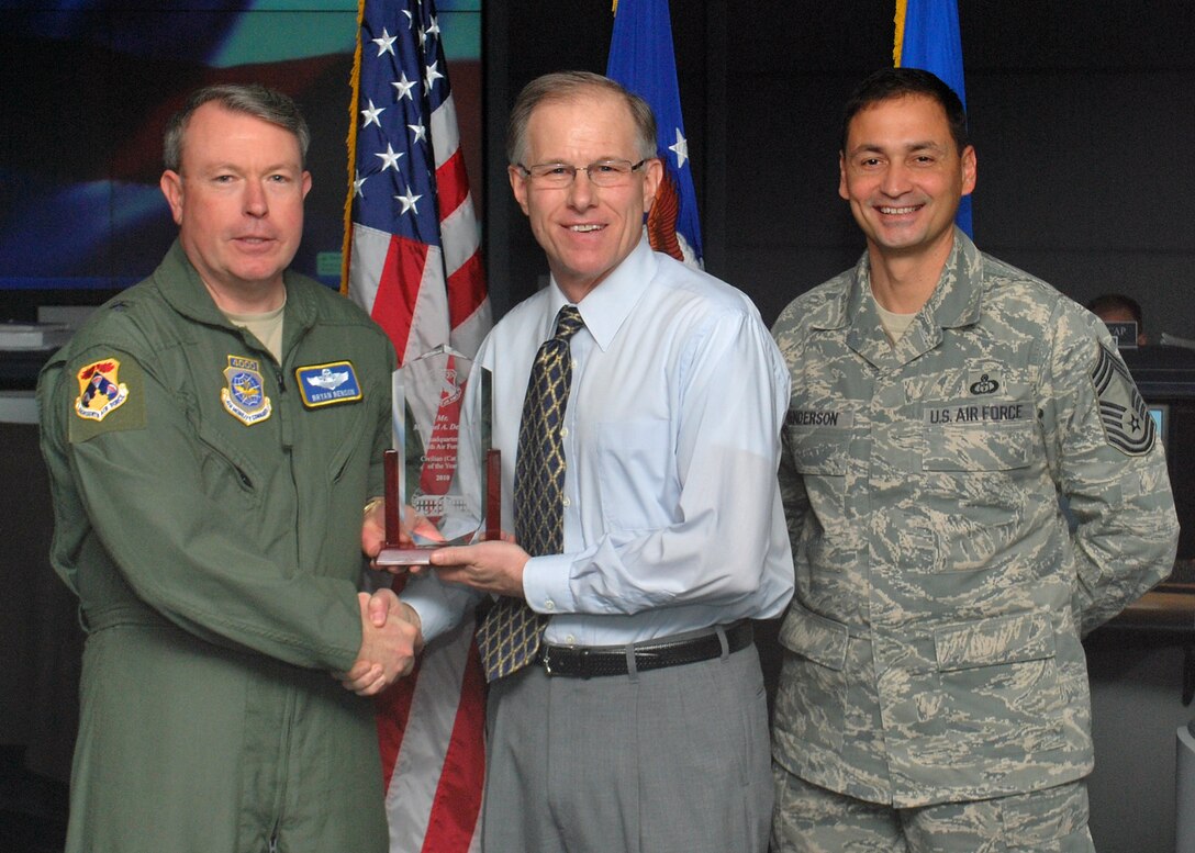 SCOTT AIR FORCE BASE, IL. -- Brig Gen. Bryan Benson (left), 18th Air Force vice commander, and Chief Master Sgt. Andrew Henderson (right), 618th Air and Space Operations Center (Tanker Airlift Control Center) superintendent, present the Headquarters, 18th Air Force Civilian of the Year (Category II) award to Michael Debolt here Jan. 20. Mr. Debolt is from the 618th Air and Space Operations Center (Tanker Airlift Control Center) here. (U.S. Air Force Photo by Capt Justin Brockhoff)