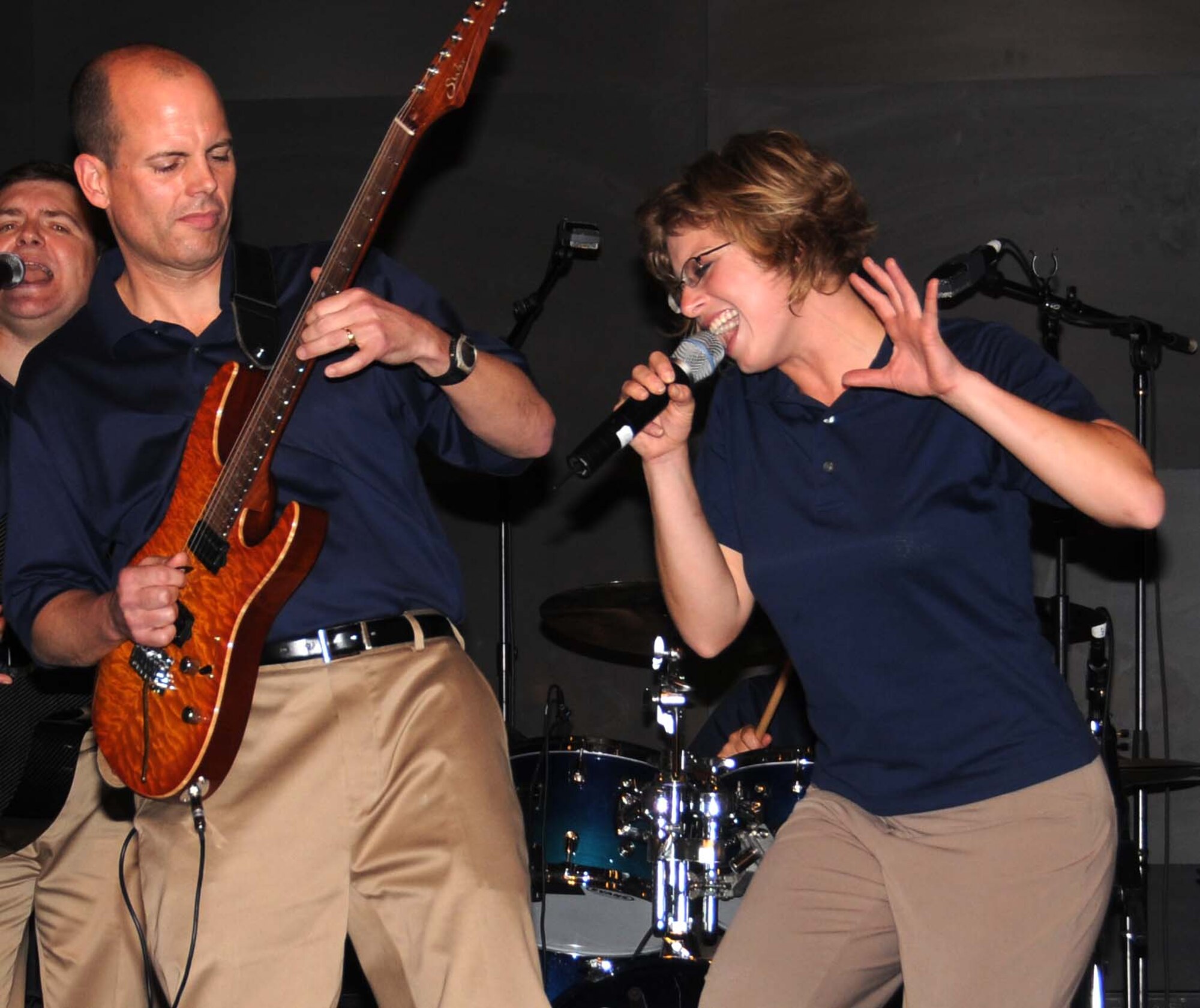 Master Sgt. Jerry Kelley, lead guitarist, and Airman 1st Class Carmen Emborski, vocalist, interact with students at the local Virginia Commonwealth University in Southwest Asia during a Jan. 22 performance of "Starlifter," the U.S. Air Forces Central Band. (U.S. Air Force photo/Staff Sgt. Anthony Graham)  
