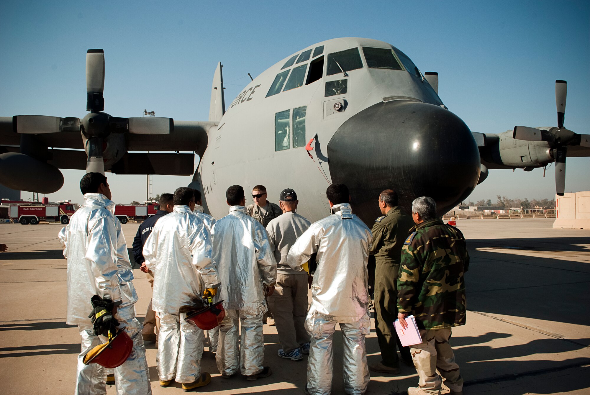Tech. Sgt. Todd Barnett, Iraq Training and Advisory Mission-Air advisor, explains safety procedures during a class on a C-130 Hercules at New Al-Muthana Air Base, Iraq, January 24.  The familiarization class was intended to broaden the depth of knowledge and experience for Iraqi Air Force firefighters. (U.S. Air Force photo by Tech. Sgt. Amy Everhard, released)