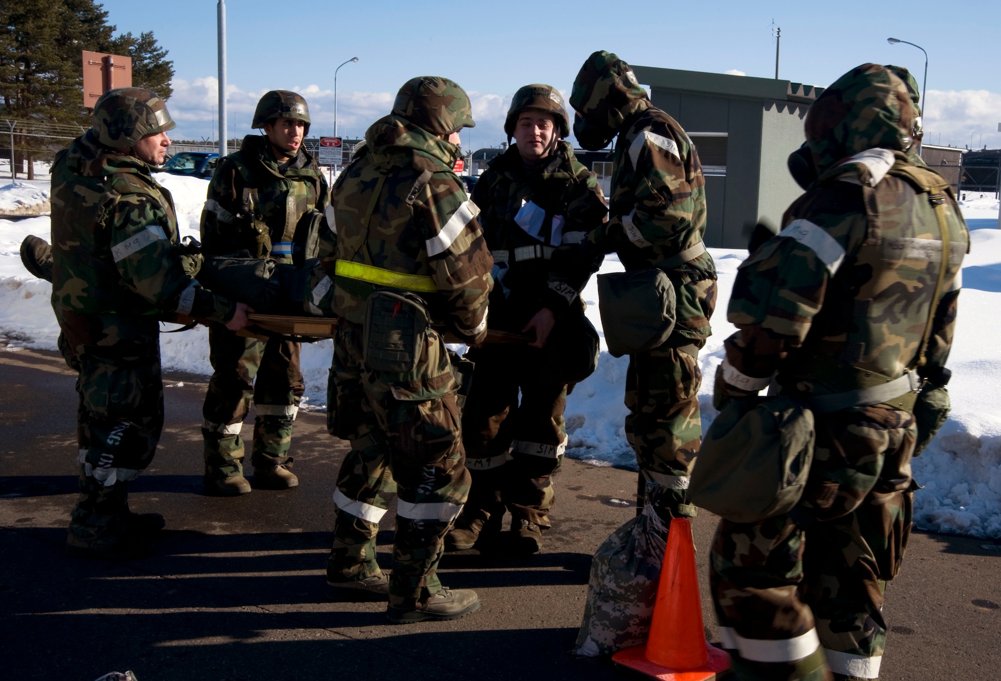 U.S Air Force members from the 35th Maintenance Squadron discuss buddy care actions with medics of the 35th Medical Group to aid an Airman injured during a (simulated) attack Jan. 27, 2011, at Misawa Air Base, Japan. Efficient patient transportation and first aid given to an injured service member within the first hour after an accident exponentially increases the member's changes of making a full recovery. (U.S. Air Force photo by Tech. Sgt. Russell McBride/Released) 