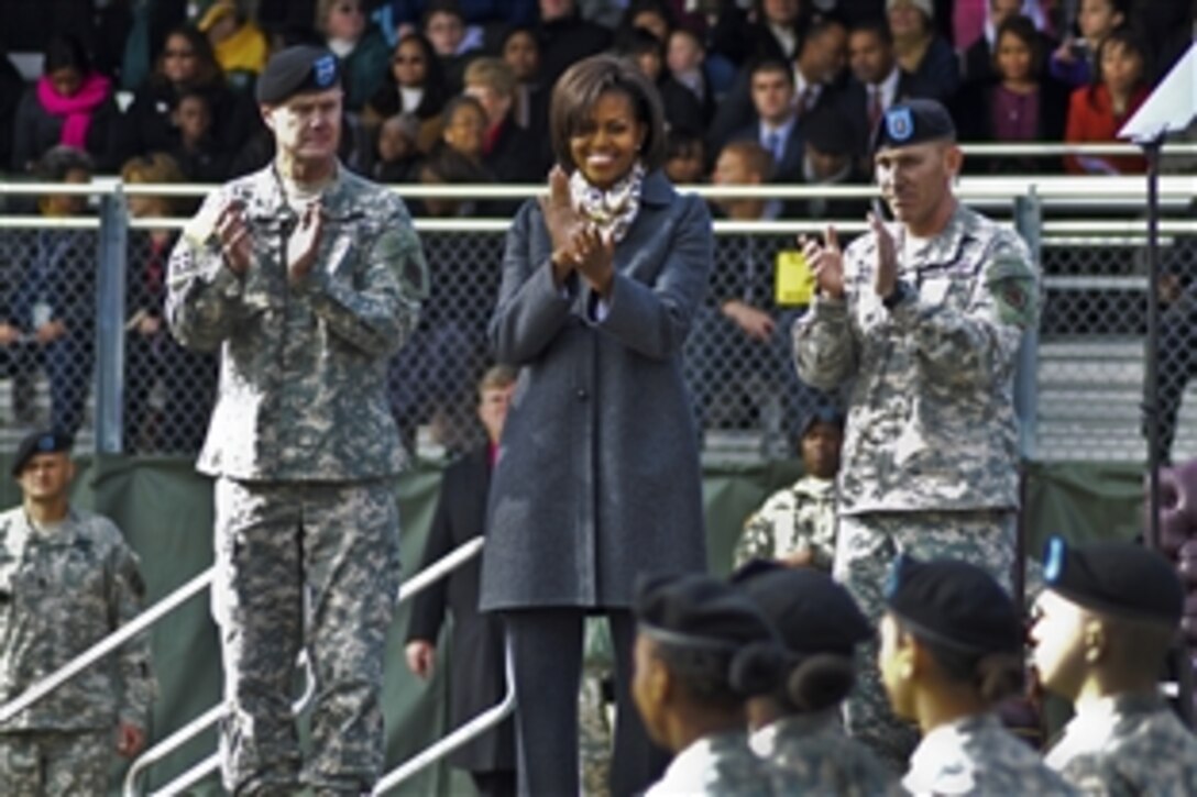 U.S. Maj. Gen. James Milano, First Lady Michelle Obama and Command Sgt. Maj. Brian Stall applaud soldiers during pass in review at the basic combat training graduation on Fort Jackson, S.C., Jan. 27, 2011. Milano is Fort Jackson's commanding general, and the soldiers are assigned to the 1st Battalion, 34th Infantry Regiment.