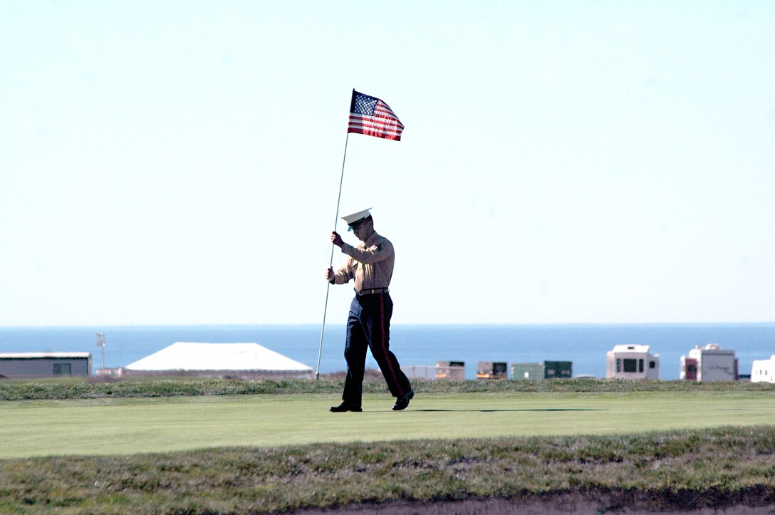 Sgt. Joseph Barton, primary marksmanship instructor, C Range, Weapons and Field Training Battalion, Edson Range, replaces the pin flying the American Flag, on the 14th hole Jan. 27. The caddies delivered the pin to Marines to guard during the Farmer’s Insurance Open Jan 27 to 30.