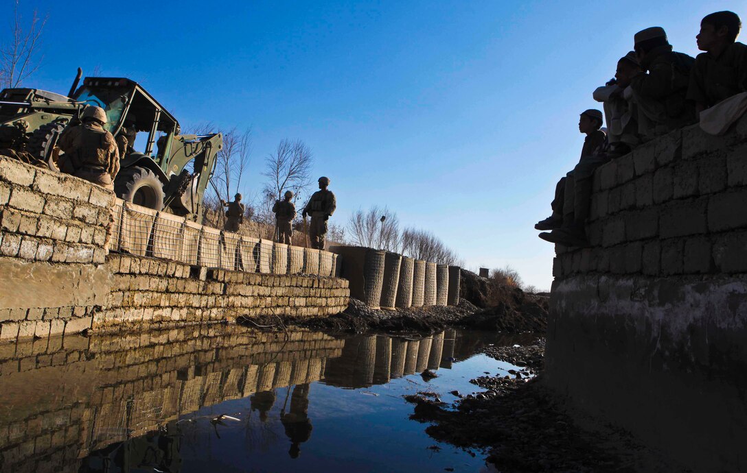 Marines with Combat Logistics Battalion 3, 1st Marine Logistics Group (Forward), use heavy equipment vehicles to repair a portion of road near Katoray, Afghanistan, Jan 27. Marines with CLB-3's Engineer Company have completed more than 10 miles of road repair on the most heavily trafficked route in Afghanistan's Helmand province.