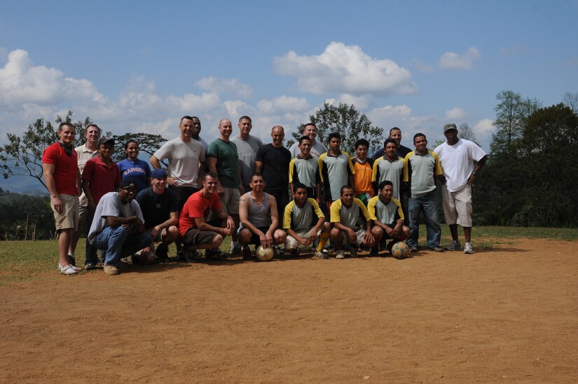 SOTO CANO AIR BASE, Honduras -- Joint Task Force-Bravo members and Las Delicias and Guayabal villagers pose for a group photo prior to a friendly game of soccer. A total of 107 volunteers hiked Jan. 22 to bring donations of food and hygiene items to those in need. After handing out the donations several JTF-B members and villagers played soccer together.  (U.S Air Force photo/Staff Sgt. Kimberly Rae Moore)
