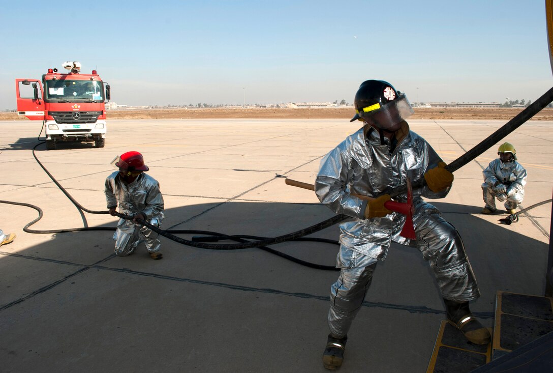 Iraqi air force firefighters feed hose to the interior crews fighting a simulated cargo fire on a C-130 Hercules Jan. 24, 2011, at New Al-Muthana Air Base, Iraq. The training was geared toward expanding Iraqi air force firefighter knowledge and response capabilities. (U.S. Air Force photo/Tech. Sgt. Todd Barnett) 