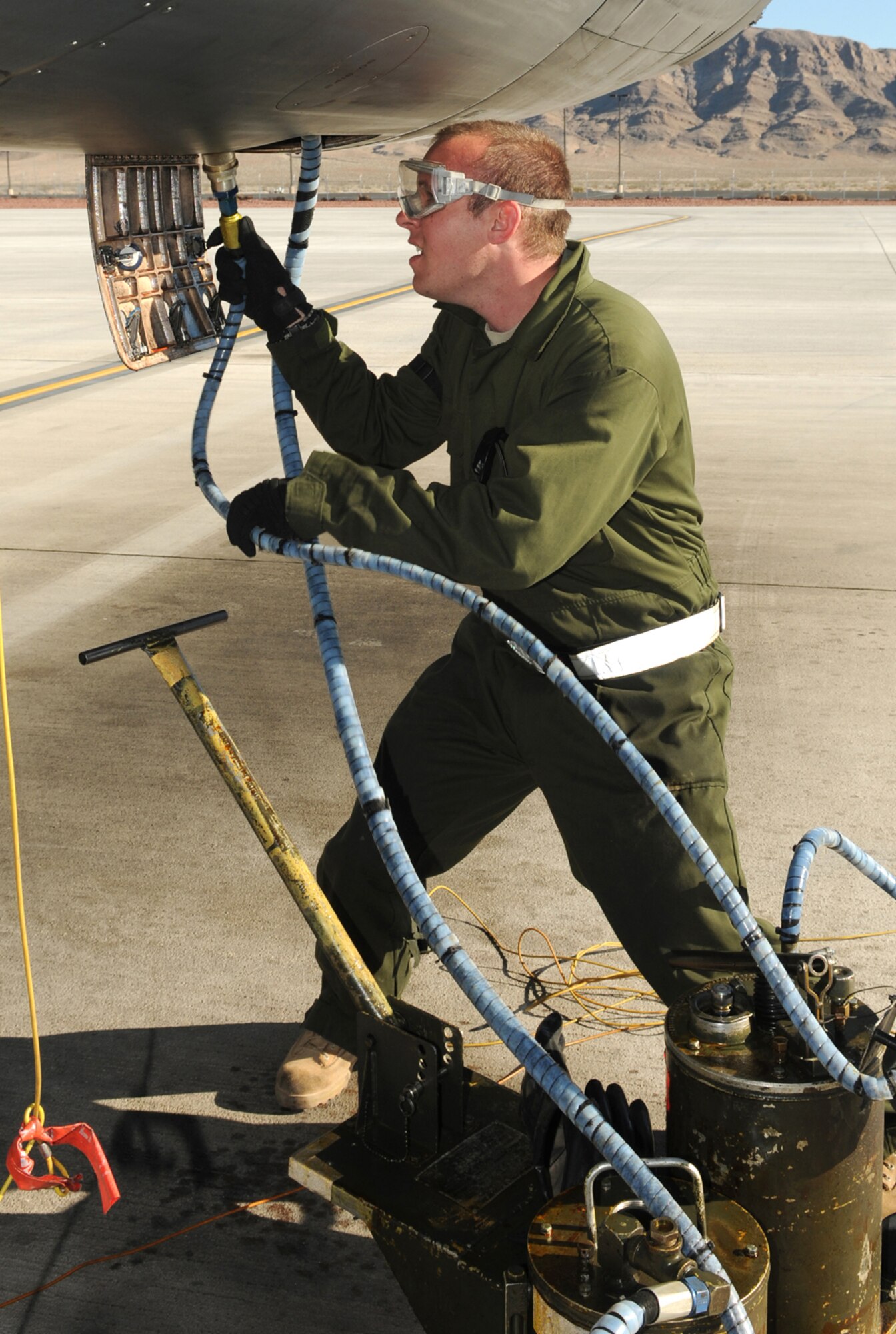 Airman 1st Class Mitch Sweeney pumps fresh oil into a gearbox on a B-1 Lancer after a mission Jan. 26, 2011, at Nellis Air Force Base, Nev. Airman Sweeney is deployed from in support of Red Flag 11-2, a combined exercise that provides a realistic combat training environment to the U.S. and its allies. Airman Sweeney is a 28th Aircraft Maintenance Squadron crew chief. (U.S. Air Force photo/Staff Sgt. Benjamin Wilson)