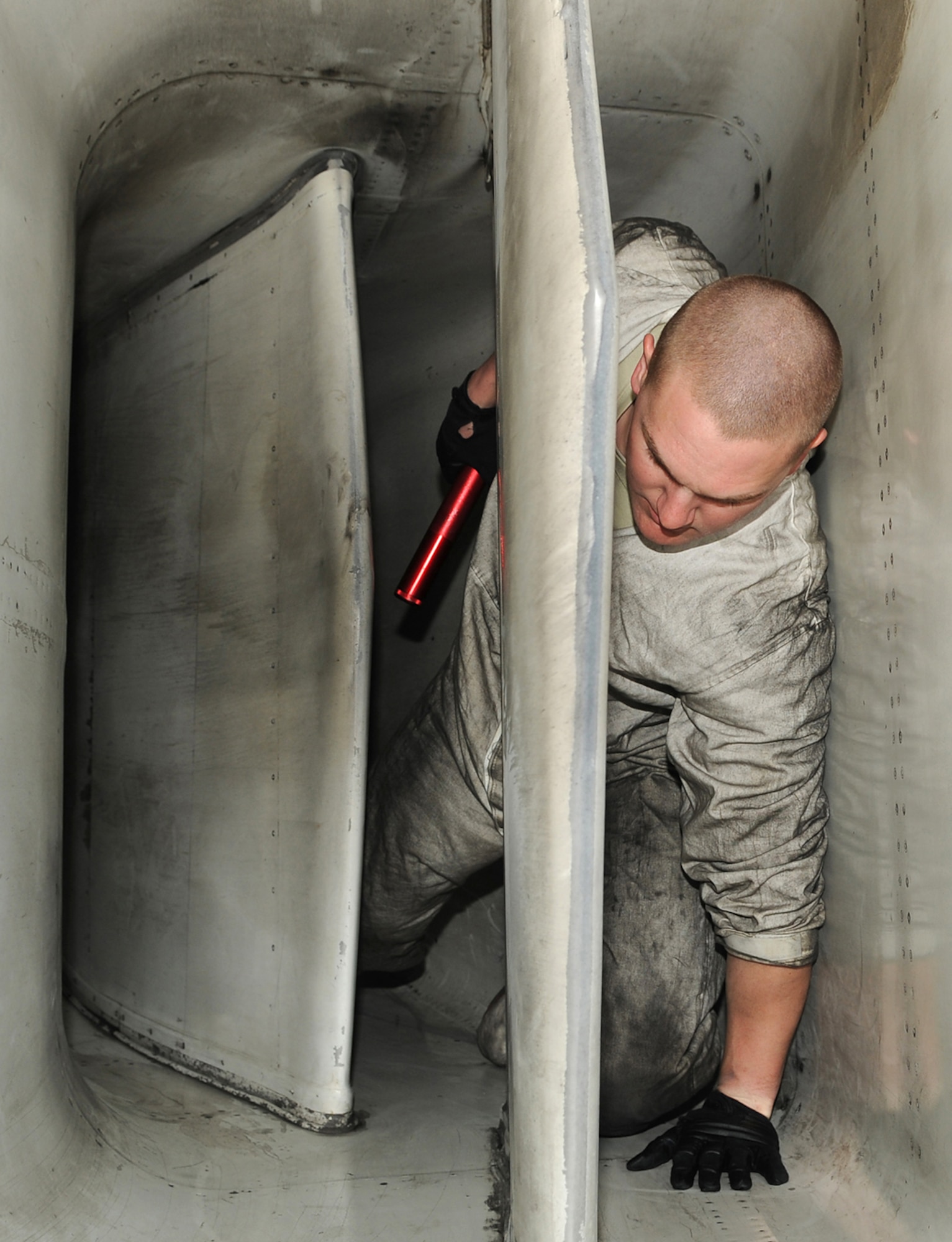Senior Airman Jeffery Wood crawls from the air intake of a B-1 Lancer after performing a post-flight engine inlet inspection Jan. 26, 2011, at Nellis Air Force Base, Nev. Airmen Wood is deployed  in support of Red Flag 11-2, a combined exercise that provides a realistic combat training environment to the U.S. and its allies. Airman Wood is a 28th Aircraft Maintenance Squadron crew chief. (U.S. Air Force photo/Staff Sgt. Benjamin Wilson)
