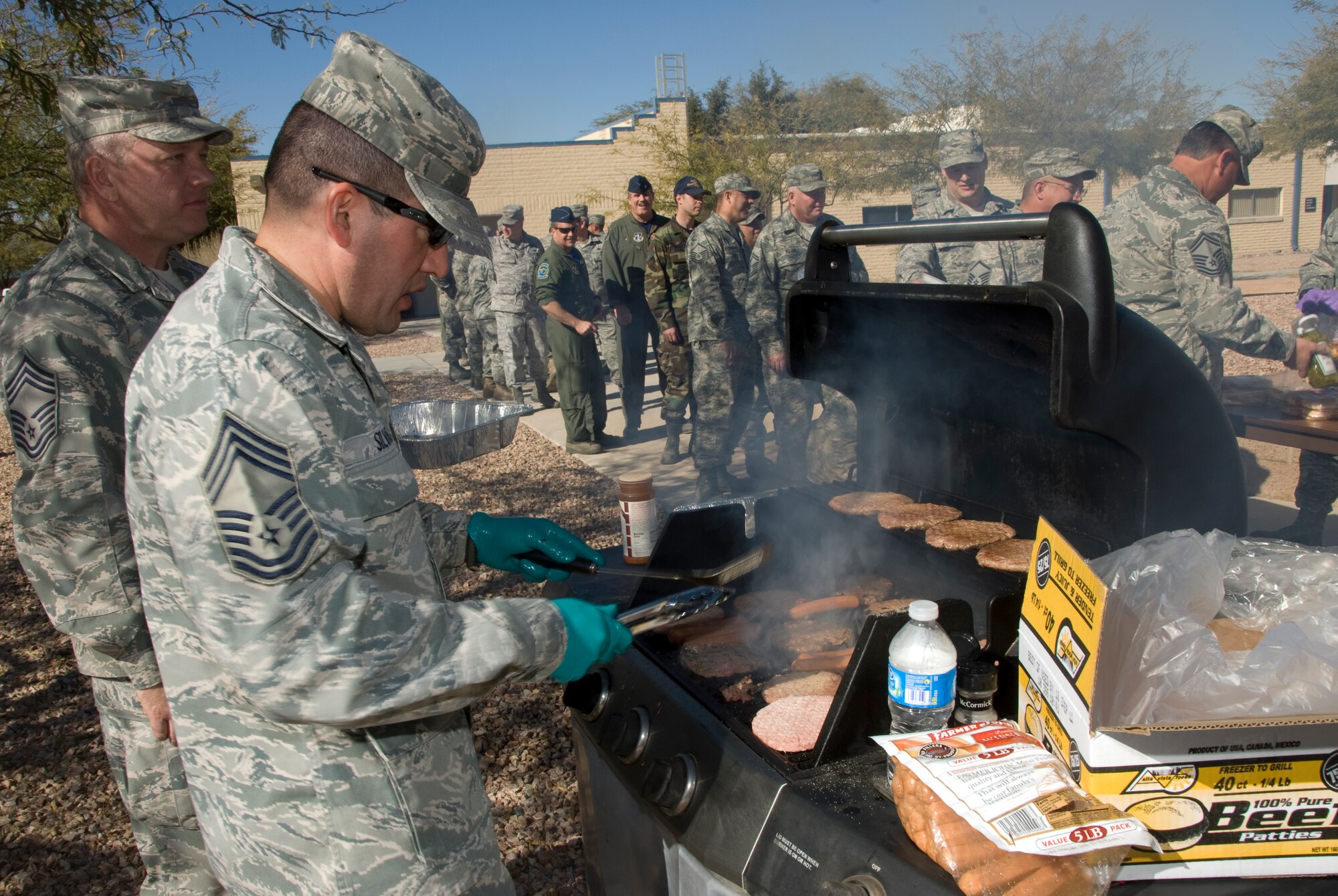 Chief Master Sgt. George Silvas grills hotdogs and hamburgers for fellow 162nd Fighter Wing members Jan. 28. The Chiefs Council here is raising funds to help junior enlisted members while taking the opportunity meet with young troops on base. (U.S. Air Force photo/Master Sgt. Dave Neve)