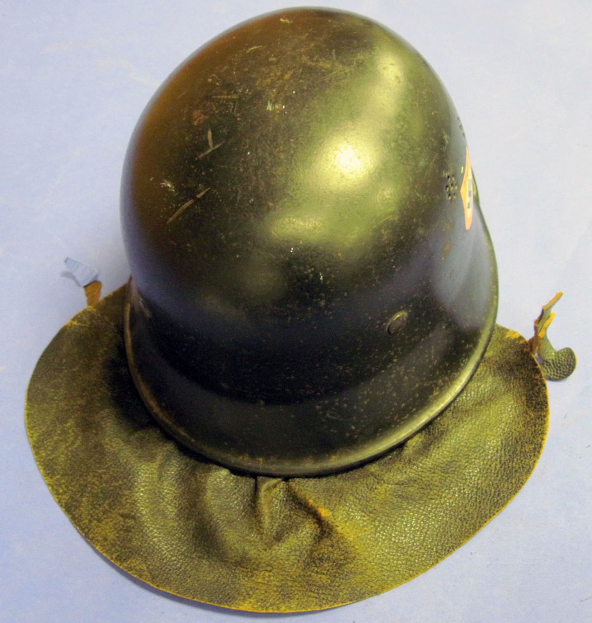 This helmet has the German police (Deutsch Polizei) and National Socialist Party (Nazi) decals and includes a leather neck cover. The German Police used this type of light-weight helmet during regular duty in hazardous situations. (U.S. Air Force photo)