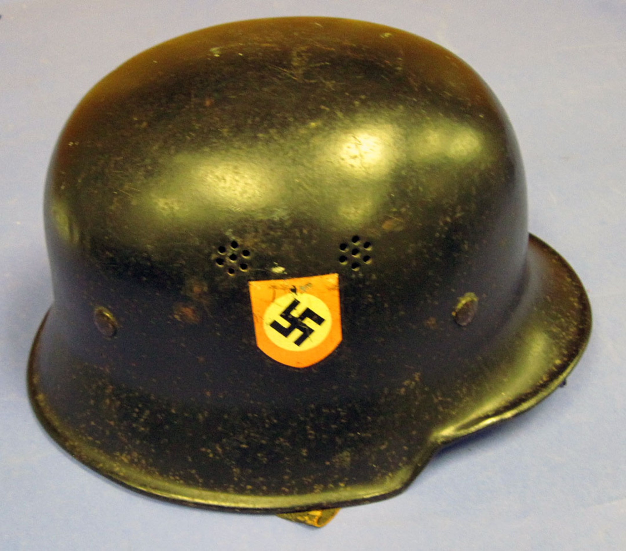 This helmet has the German police (Deutsch Polizei) and National Socialist Party (Nazi) decals and includes a leather neck cover. The German Police used this type of light-weight helmet during regular duty in hazardous situations. (U.S. Air Force photo)