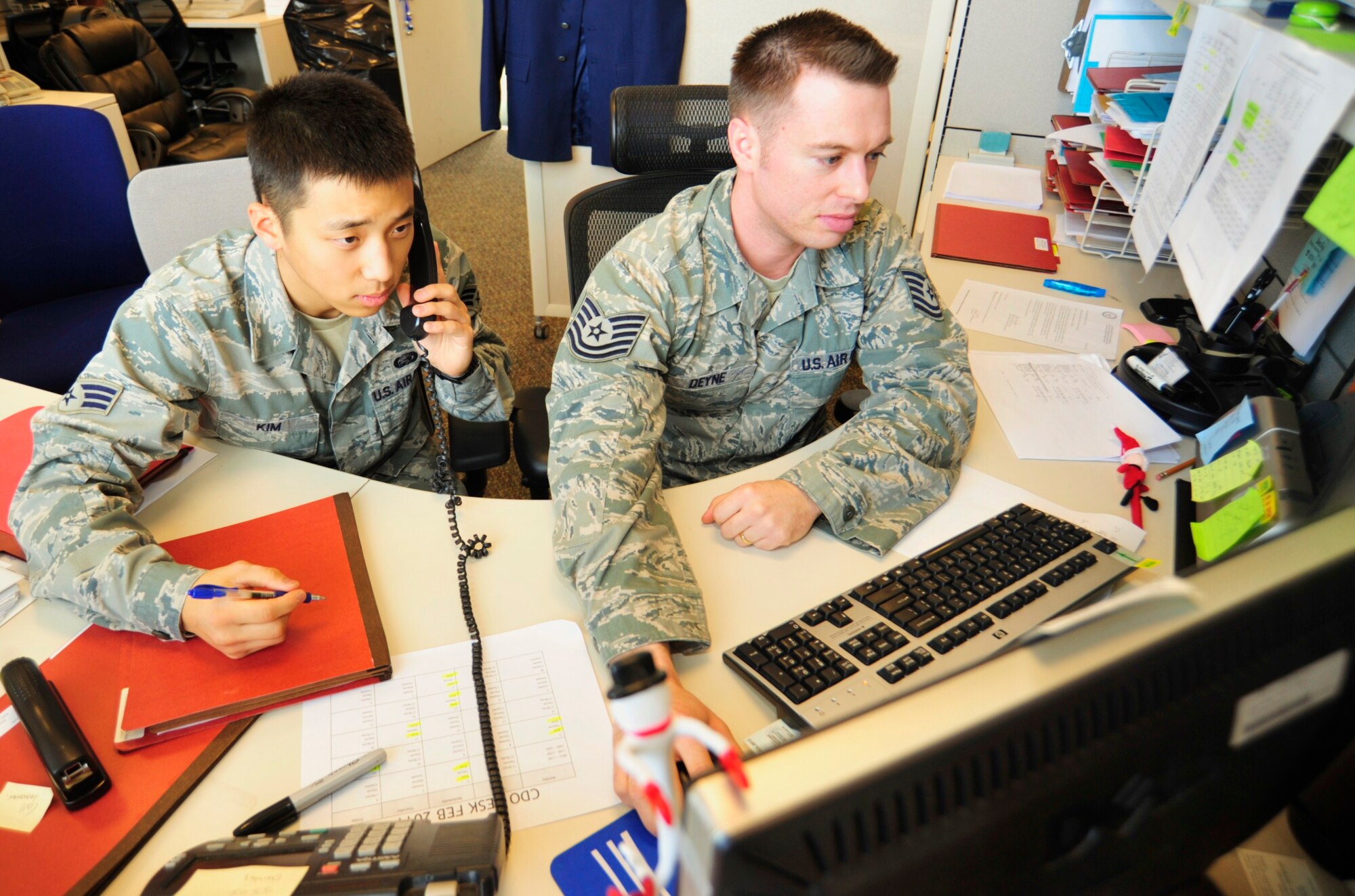 Senior Airman Daniel Kim, left, and Tech. Sgt. Steven Deyne, both 627th Force Support Squadron military personnel flight technicians, help a customer navigate through the online leaveWEB system Jan. 26 at Joint Base Lewis-McChord, Wash. The personnel flight is responsible for all paperwork related to a change of assignment, retirement, incoming and outgoing Airmen, re-enlistment and more. (U.S. Air Force photo/Airman Leah Young)