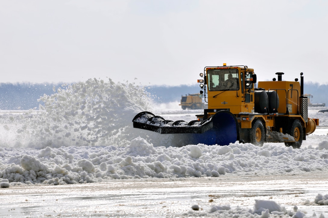 A 11th Civil Engineer Squadron snow removal team clears the Joint Base Andrews, Md., flightline Jan. 27, 2011. The 11th Civil Engineer Squadron snow removal team kept the runway clear for normal flightline operations after a snow storm dropped six inches of snow and sleet the night before. (U.S. Air Force by Senior Airman Perry Aston)