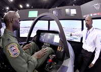 Lt. Col. Ryan Sparkman, 560th Flying Training Squadron, test drives the Lockheed Martin F-35 cockpit simulation at the 2011 Air Education and Training Command Symposium and Exposition Jan. 20. The symposium featured more than 90 seminars on a variety of education, training and innovation topics by experts from across the Air Force. (U.S. Air Force photo/Robbin Cresswell)