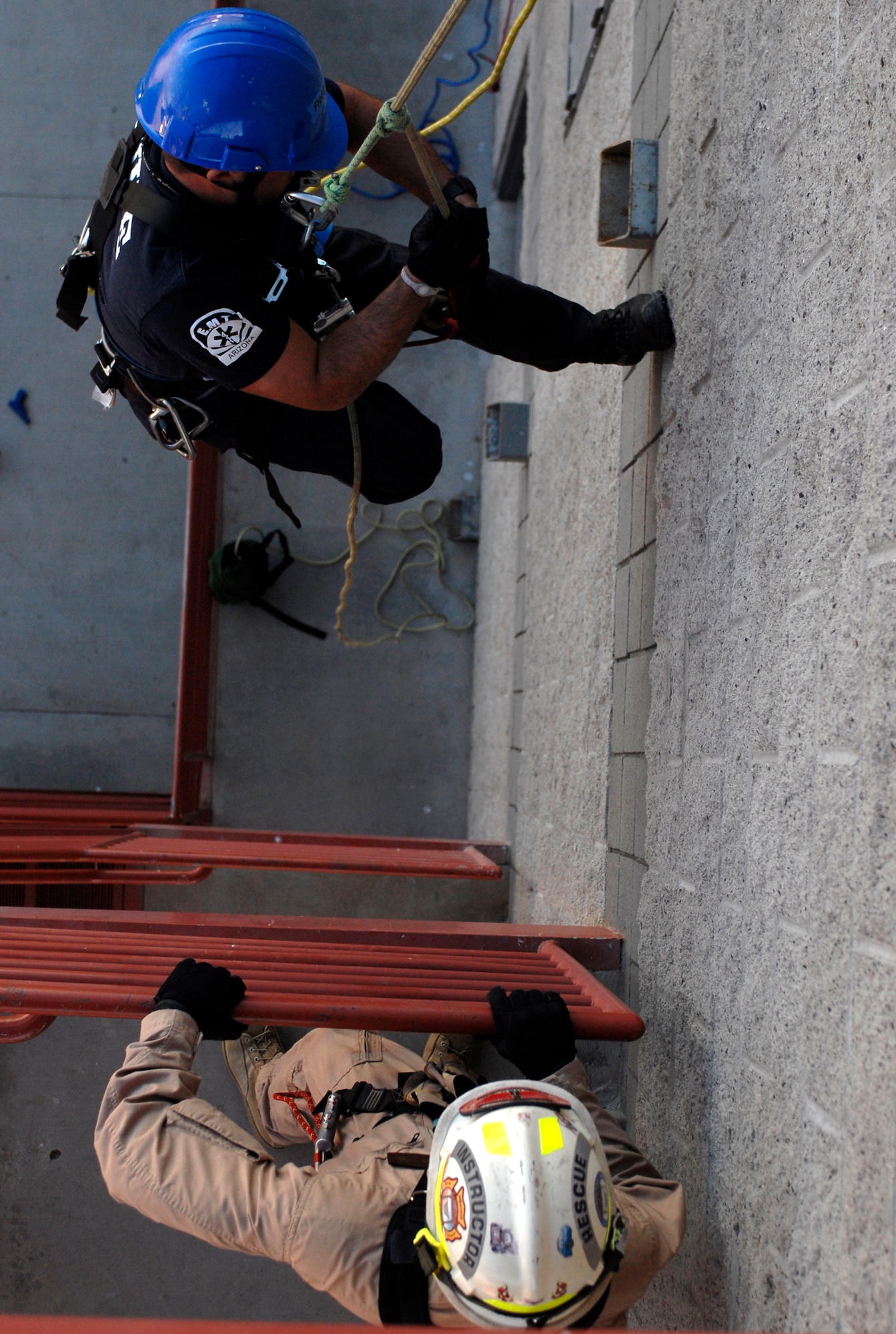 Mark Finchum, 56th Civil Engineer Squadron firefighter, performs a self rescue while instructor Staff Sgt. David Hagenbuch, 312th Training Squadron, Goodfellow Air Force Base, Texas, stands by evaluating him during the Rescue Technician 1 Course held at the Glendale Regional Public Safety Training Center.  (U.S. Air Force photo/Airman 1st Class Sandra Welch)