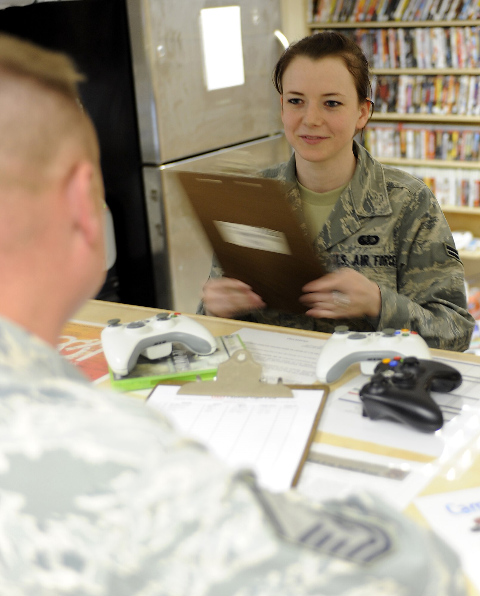 Airman 1st Class Megan Batesole helps an Airman sign up for an event Jan. 28, 2011, at Kandahar Airfield, Afghanistan. The 451st Expeditionary Force Support Flight Morale, Welfare and Recreation team hosts nightly events or tournaments to boost the quality of life of nearly 2,000 Airmen on the base. Airman Batesole is a 451st EFSF recreation specialist. (U.S. Air Force photo/Senior Airman Willard E. Grande II/Released)