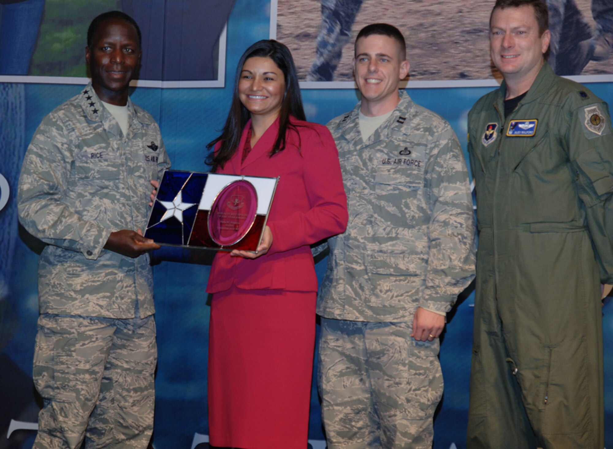 Gen. Edward Rice, AETC commander, presents Perla Hopkins with the Key Spouse of the Year Award for the MAJCOM. Also pictured are: Mrs. Hopkins husband, Capt. Bart Hopkins, 14th OSS Weather Flight, and Lt. Col. Alex Walford, 14th OSS commander. 